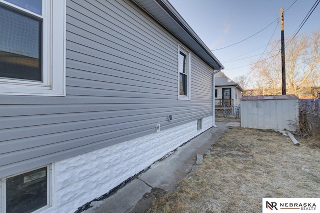 view of side of home featuring a storage shed