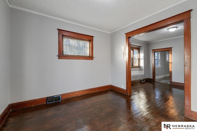 spare room featuring ornamental molding, dark wood-type flooring, and a textured ceiling