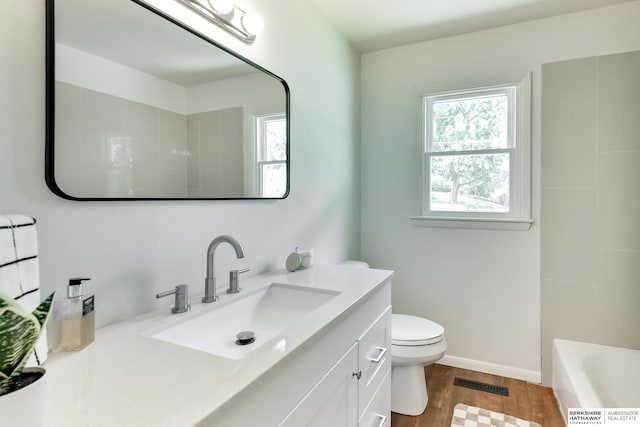 bathroom with wood-type flooring, toilet, and vanity