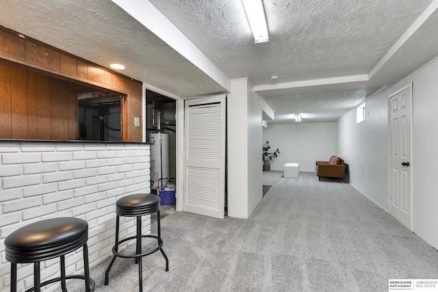 interior space with a textured ceiling, light carpet, and water heater