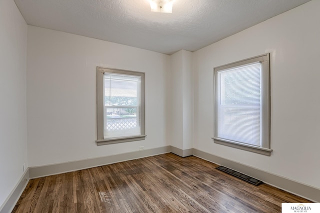 spare room with hardwood / wood-style flooring and a textured ceiling