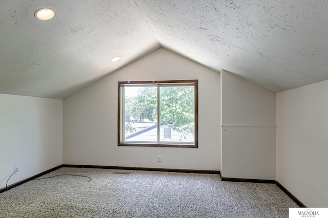 bonus room with a textured ceiling, carpet floors, and lofted ceiling