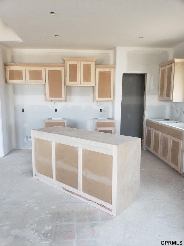 kitchen with a center island and light brown cabinetry