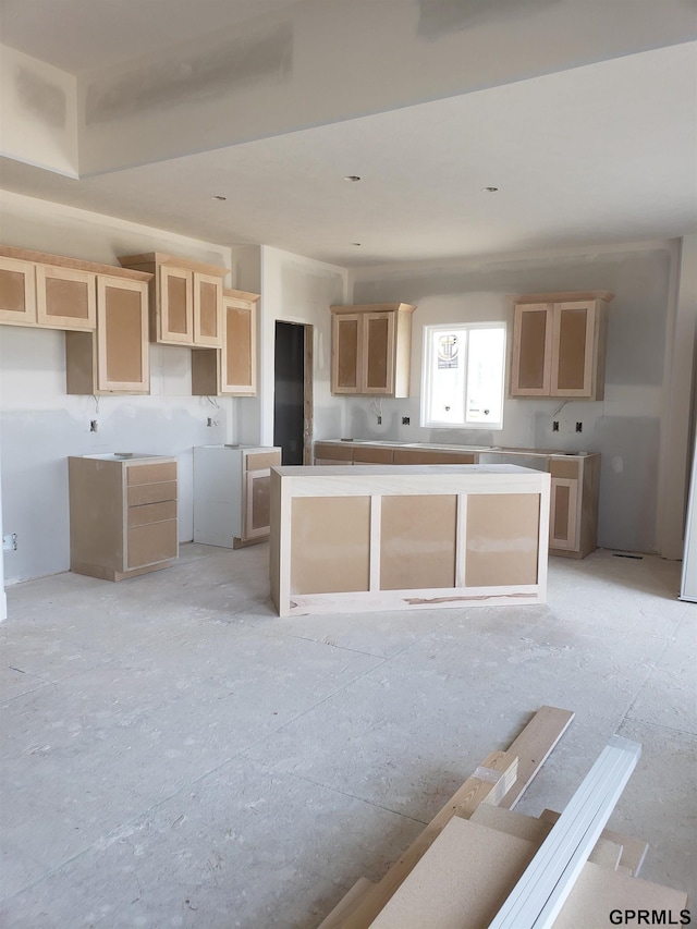 kitchen with a center island and light brown cabinetry