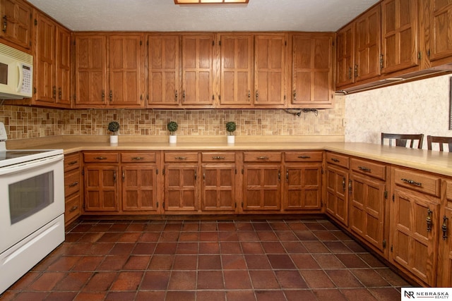 kitchen featuring white appliances, a textured ceiling, and tasteful backsplash