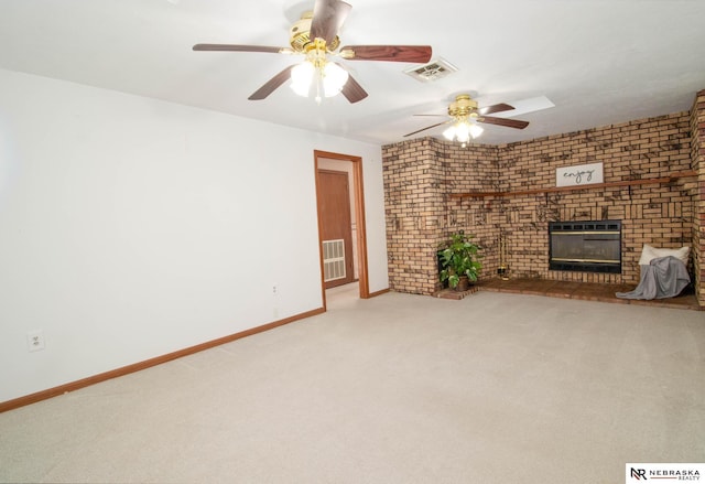 unfurnished living room with a fireplace, light colored carpet, brick wall, and ceiling fan