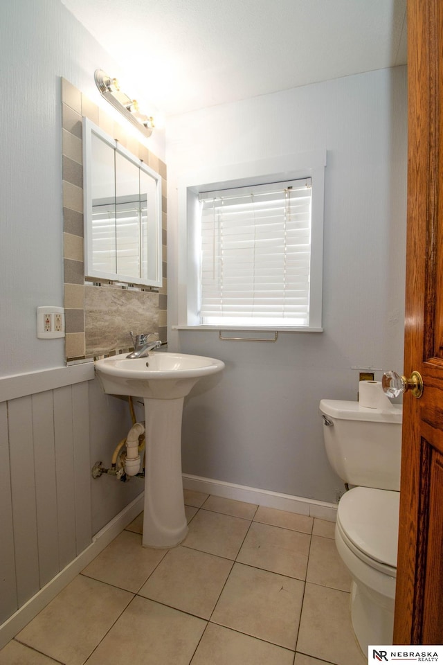 bathroom featuring toilet, radiator heating unit, and tile patterned floors