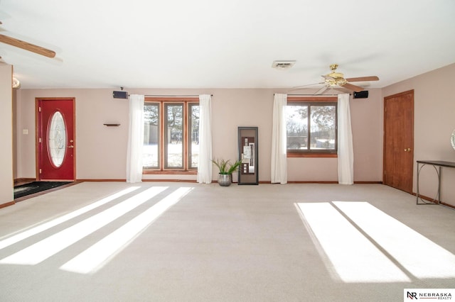 unfurnished living room featuring light carpet and ceiling fan