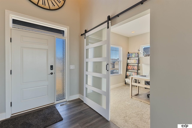 entryway with dark hardwood / wood-style flooring and a barn door