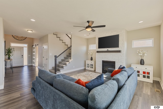 living room with ceiling fan, a fireplace, and hardwood / wood-style floors