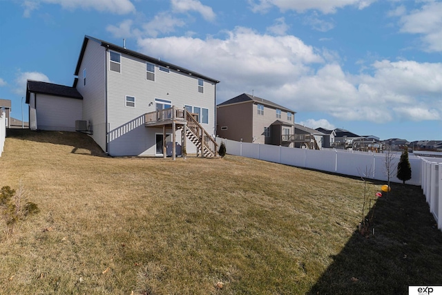 rear view of house with central AC, a deck, and a lawn