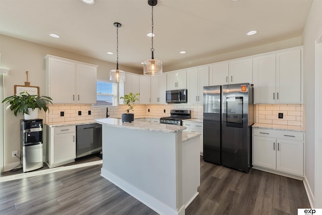 kitchen with white cabinetry, stainless steel appliances, light stone countertops, a kitchen island, and decorative light fixtures