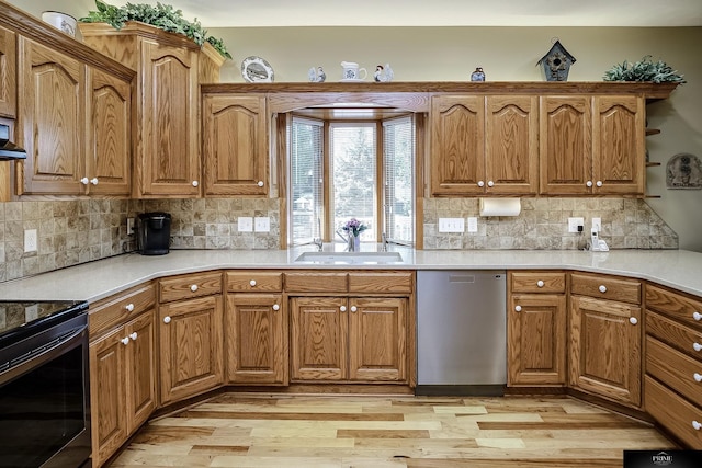 kitchen featuring sink, light hardwood / wood-style floors, decorative backsplash, and stainless steel appliances