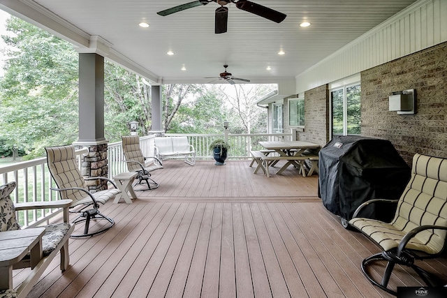 wooden terrace featuring covered porch, ceiling fan, and area for grilling