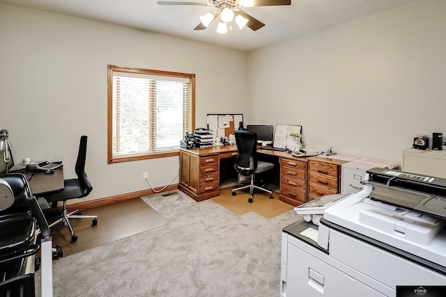 carpeted office space featuring ceiling fan