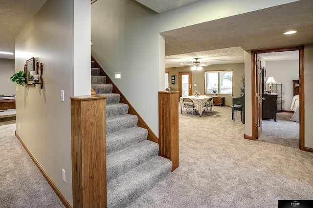 stairs featuring carpet floors, a textured ceiling, and ceiling fan