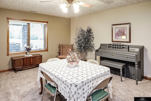 carpeted dining space featuring ceiling fan and a textured ceiling