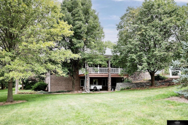 rear view of house featuring a deck and a lawn