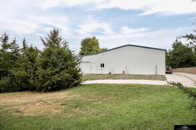 view of side of home with an outbuilding and a lawn