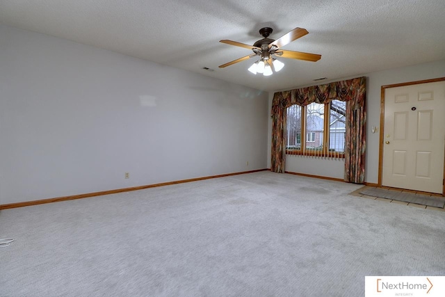 spare room featuring ceiling fan, light colored carpet, and a textured ceiling