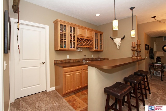 bar featuring sink, dark colored carpet, and hanging light fixtures