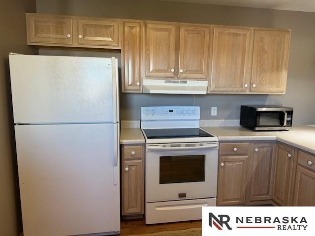 kitchen featuring white appliances and light brown cabinetry