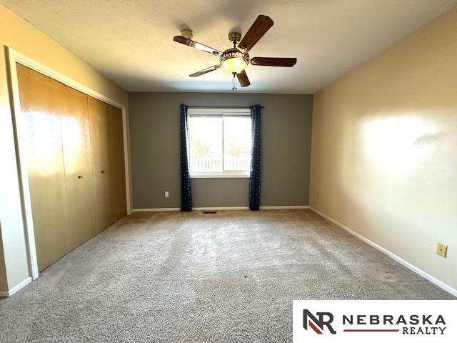 unfurnished bedroom with a closet, ceiling fan, and carpet floors