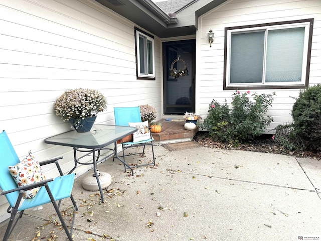 view of exterior entry featuring a patio area