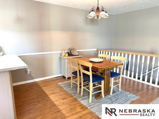 dining room with a notable chandelier, a textured ceiling, and wood-type flooring