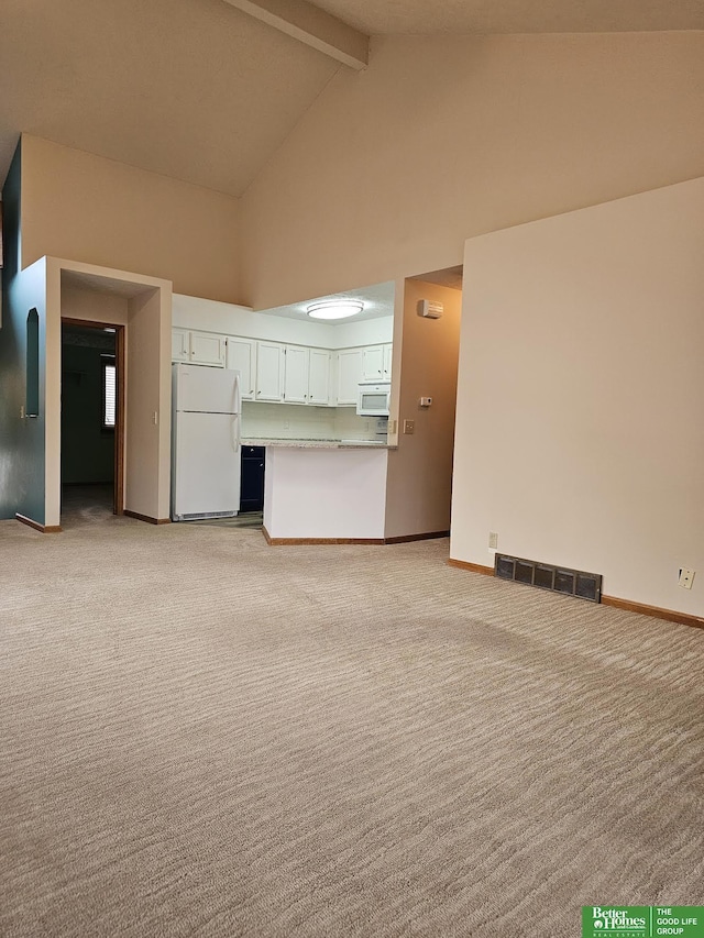 unfurnished living room featuring light carpet, beam ceiling, and high vaulted ceiling