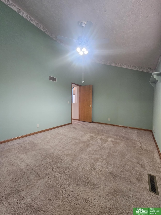 empty room featuring ceiling fan, a textured ceiling, and carpet