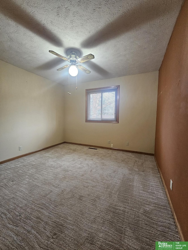 carpeted spare room featuring a textured ceiling and ceiling fan