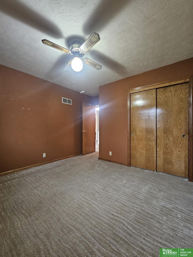 unfurnished bedroom featuring ceiling fan, a textured ceiling, and carpet flooring