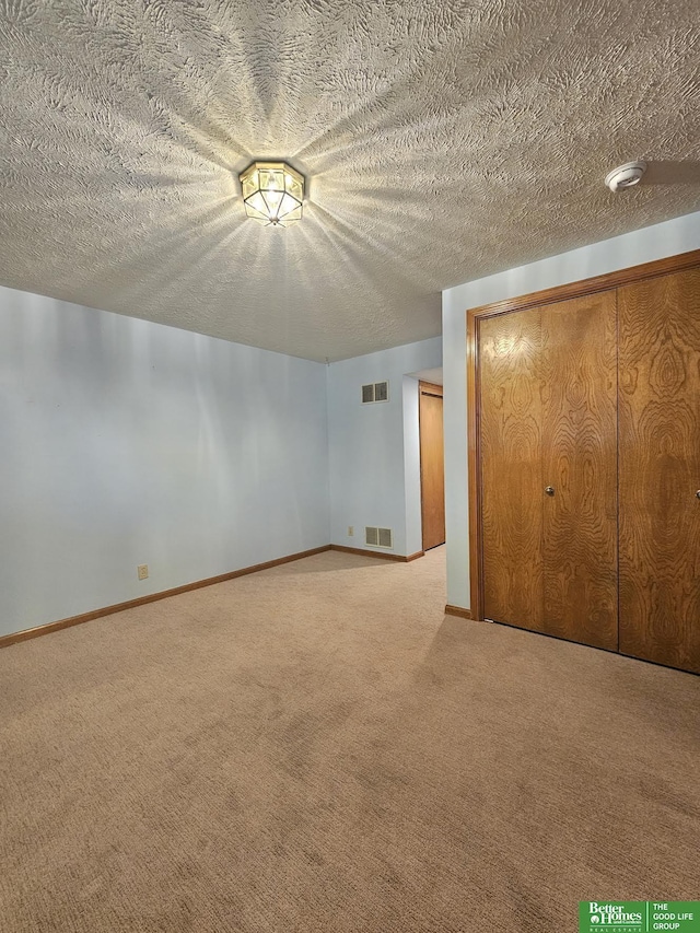 additional living space with carpet floors and a textured ceiling