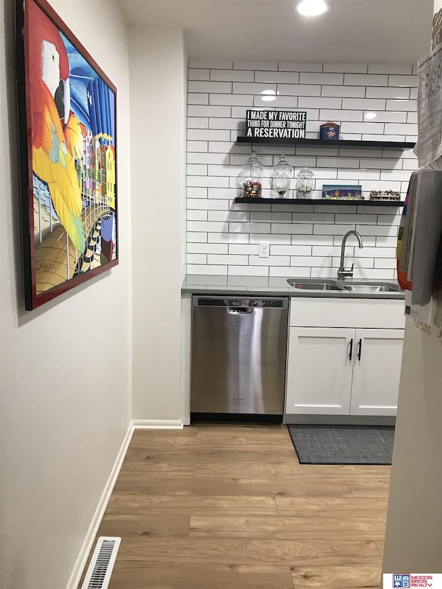 bar with white cabinets, dishwasher, tasteful backsplash, sink, and light hardwood / wood-style flooring