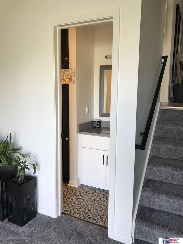 staircase featuring carpet flooring