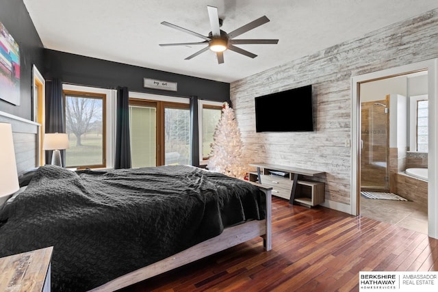 bedroom featuring ceiling fan, dark wood-type flooring, and ensuite bath