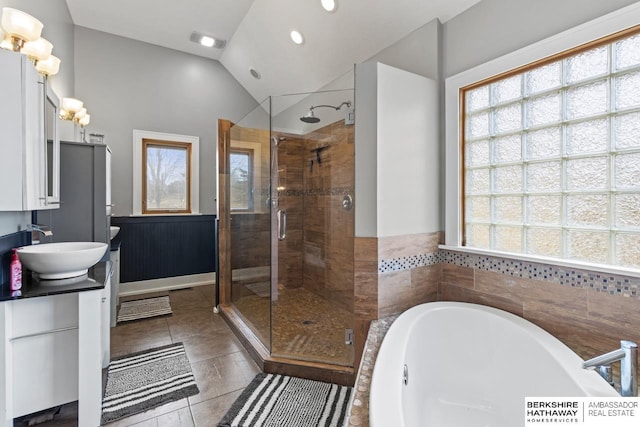 bathroom with tile patterned flooring, shower with separate bathtub, lofted ceiling, and vanity