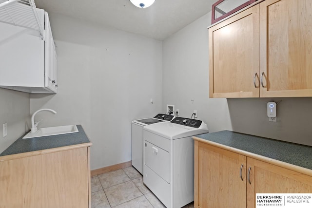 laundry area featuring sink, cabinets, light tile patterned floors, and washing machine and clothes dryer