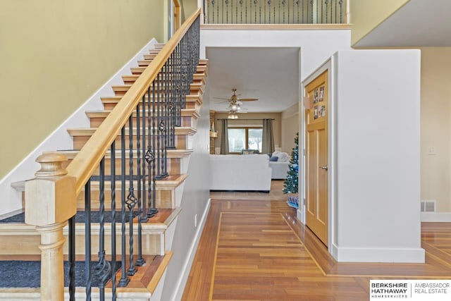 stairs featuring hardwood / wood-style floors and ceiling fan