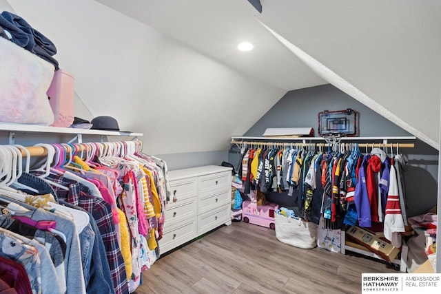 walk in closet featuring hardwood / wood-style flooring and vaulted ceiling