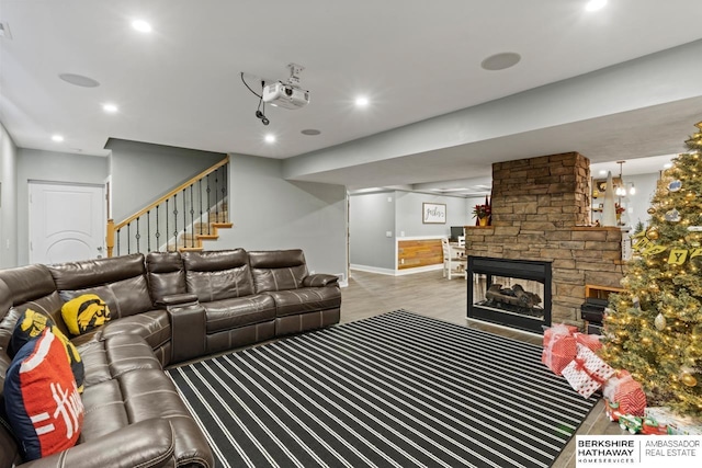 living room with hardwood / wood-style floors and a stone fireplace