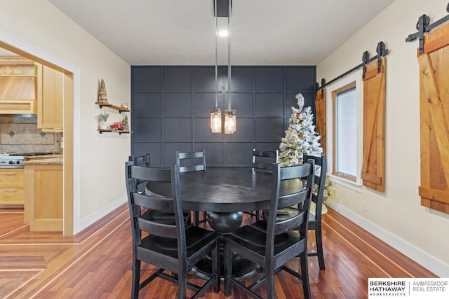 dining room featuring dark wood-type flooring and a barn door