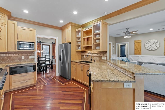 kitchen featuring stainless steel appliances, decorative backsplash, a kitchen breakfast bar, light brown cabinetry, and kitchen peninsula