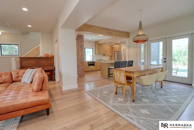 dining space featuring light wood-type flooring and french doors