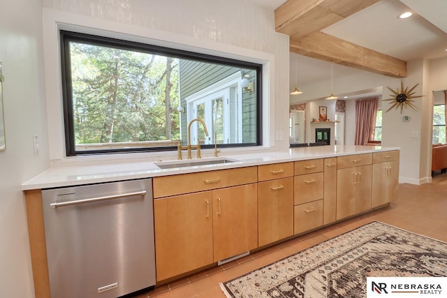 kitchen featuring pendant lighting, dishwasher, sink, light tile patterned flooring, and light stone counters