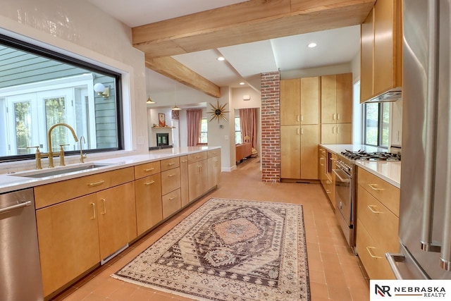 kitchen with sink, a wealth of natural light, stainless steel appliances, and beamed ceiling