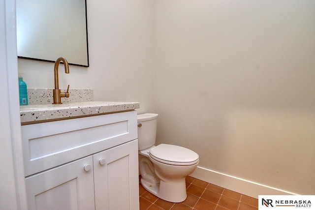 bathroom with toilet, vanity, and tile patterned flooring