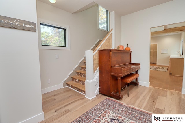 stairs with sink and hardwood / wood-style floors