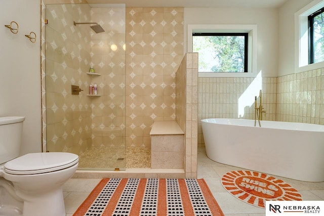 bathroom featuring tile walls, toilet, shower with separate bathtub, and tile patterned flooring